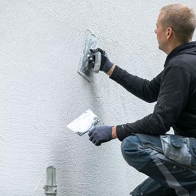 Builder in Caterham applying external plastering